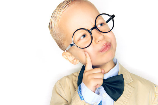 Little boy wearing glasses and a bowtie deep in thought