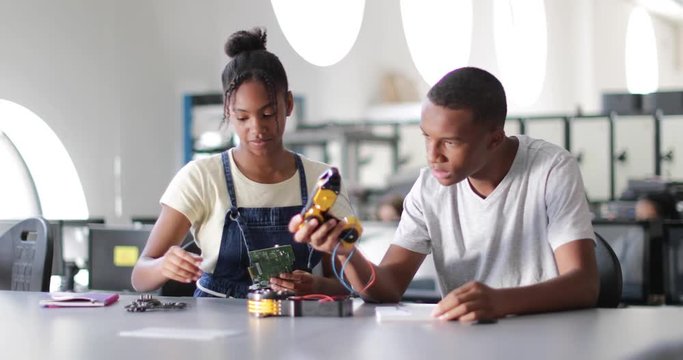 High school students working on a robotic arm in class
