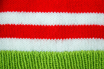 Colorful christmas red, white and green knitted pattern of Santa claus helper hat.