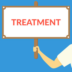 TREATMENT. Hand holding wooden sign