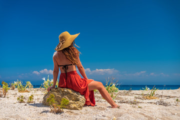 Woman in red outfit posing at the beach