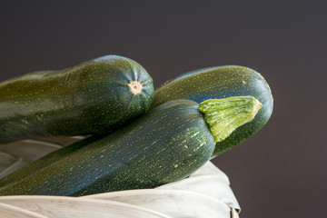 courgettes dans un panier sur fond noir