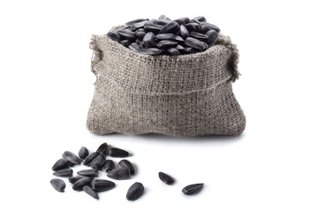Black sunflower seeds in a burlap sack, isolated on white background