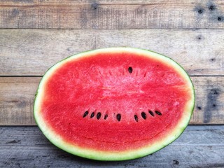 Fototapeta na wymiar A slice half of fresh watermelon on a wooden table.