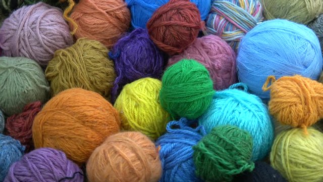 Rotating many colorful yarn wool balls for knitting background