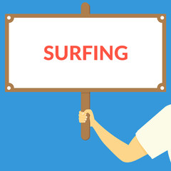 SURFING. Hand holding wooden sign