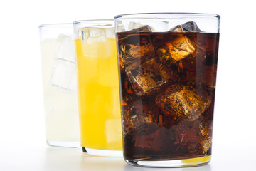Vasos con refrescos de cola, naranja y limón