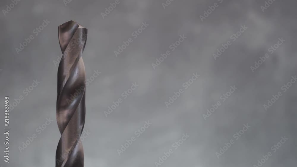 Poster Metal drill bit rotation on a dark background. Macro view.