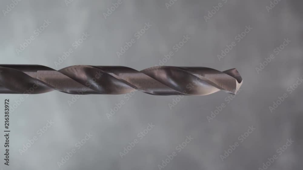Aufkleber metal drill bit rotation on a dark background. macro view.