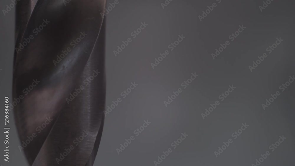 Poster Metal drill bit rotation on a dark background. Macro view.