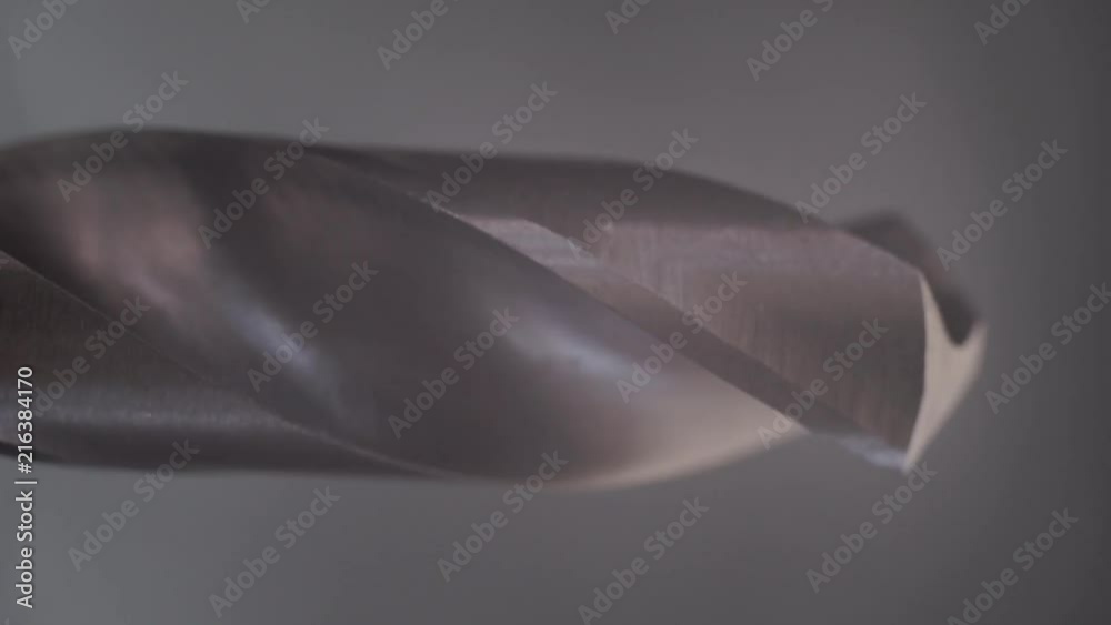 Poster Metal drill bit rotation on a dark background. Macro view.