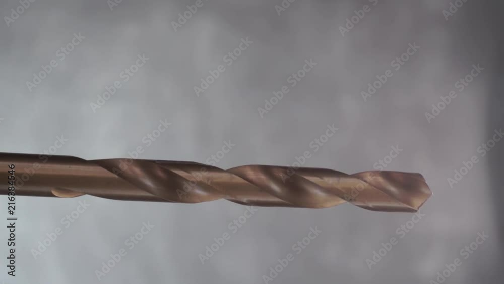 Poster Yellow drill bit rotation on a dark background. Macro view.