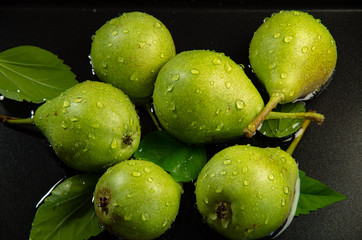 Green pears with leaves are in the water