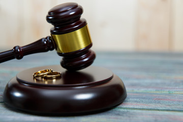 Closeup of wedding rings on wooden mallet at table