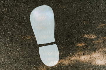 Big white clear step trace on the asphalt with sun strokes.