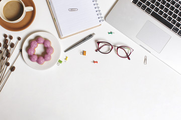 Flat lay workspace picture, cup of coffee, donut , notebook and pen on white background. Business workplace concept. Work desktop with coffee, enjoy working.