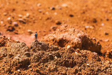 Business man on the rocky area is rocky. Imagine doing business on Mars.