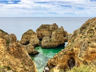 Algarve landscape with yellow rocks, sky and Atlantic ocean. Portugal Atlantic coast with turquoise watercolor in the ocean.