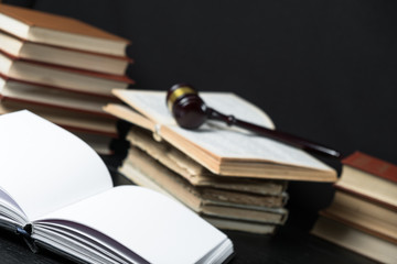 Judge gavel beside pile of books on wooden background