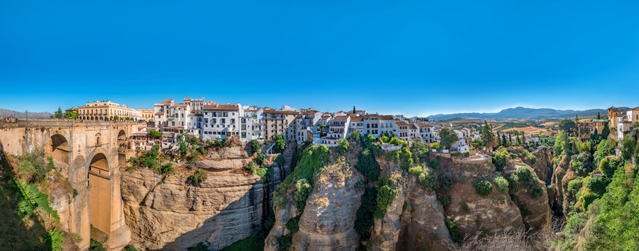Panorama view of the Puente Nuevo bridge and the houses built on the edge of the cliff, in the ancient city of Ronda, Spain