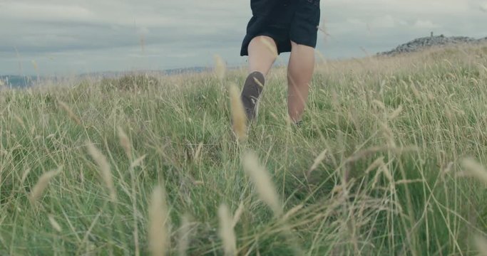 Feet and legs of young woman walking on the moor