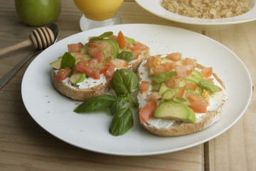 Homemade Healthy Toast sandwich with Avocado, cheese cream and tomatoe on wooden board. Breakfast healthy food.