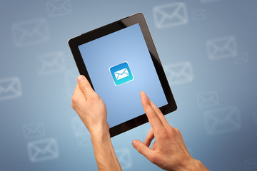 Female fingers touching tablet with mail icon on it 
