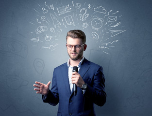 Businessman speaking into microphone with mixed doodles over his head