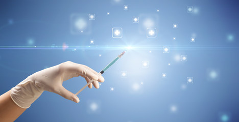 Female doctor hand holding syringe with shiny crosses in the background