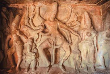 Example of indian artworks from near 7th century, Ganesha and dancing Shiva with many heands inside ancient cave with Hindu temple, India