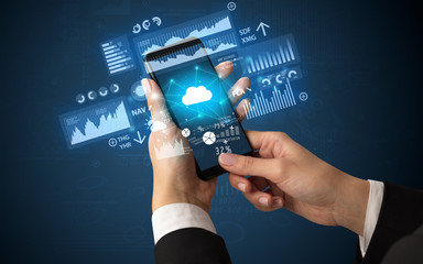 Female hand using smartphone with financial tracking concept illustrated by graphs and symbols