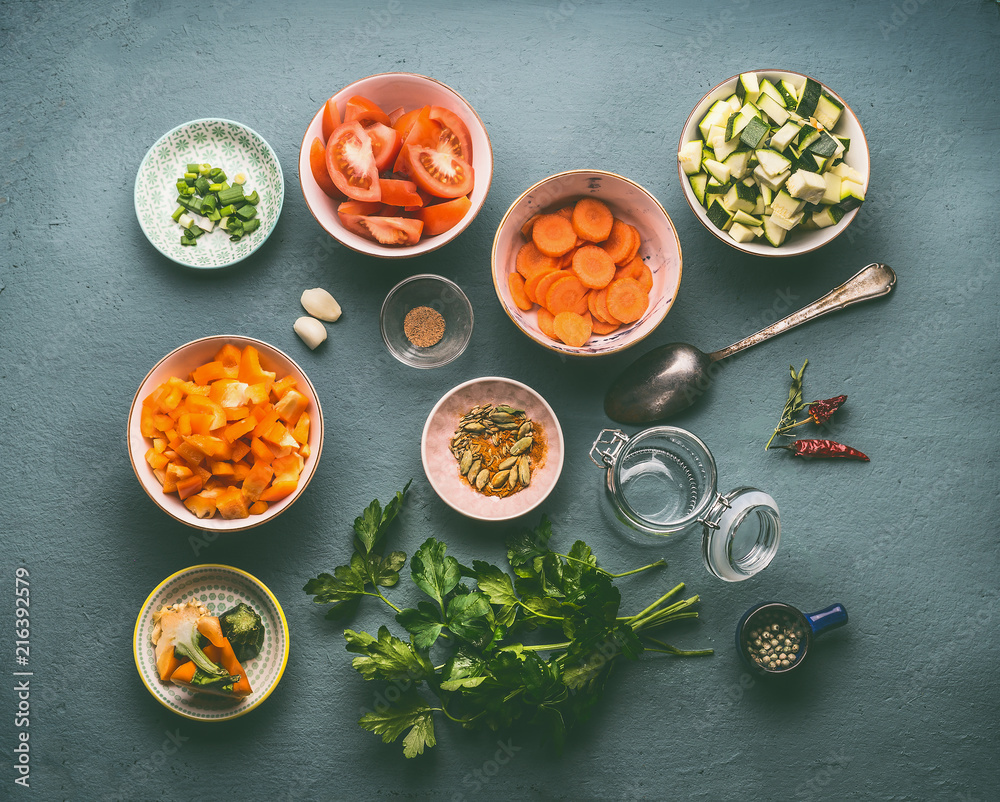 Wall mural healthy vegetarian ingredients bowls: diced vegetables, herbs and spices on dark background, top vie