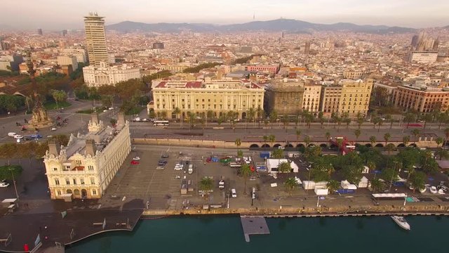 Wide angle aerial view flying horizontally over the harbor in Barcelona revealing the Christopher Columbus Monument