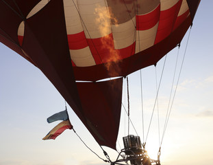 Hot air balloon being inflated in preparation for flight. Gas burner fills the canopy of a balloon with hot air. Pumping the fire to apply hot air into fireproof air-balloon.