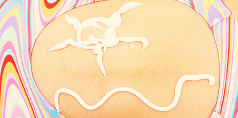 Sun and wave painted with sunscreen on the little girl's back in a swimsuit. Concept for skin cancer or sunburn uv rays protection.