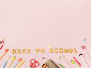 Colorful background with lettering Back to School made of cookies on pink pastel background