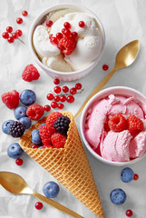 Ice cream cone with assortment of fruits and ice cream flavours viewed from above. Homemade raspberry and vanilla ice cream in a cups. Top view