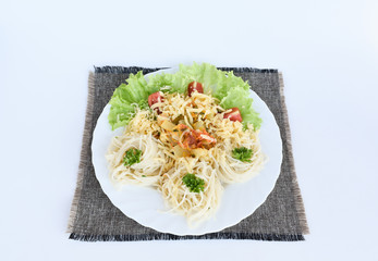 Spaghetti on a white plate with vegetables