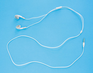 earbuds or earphones on blue background