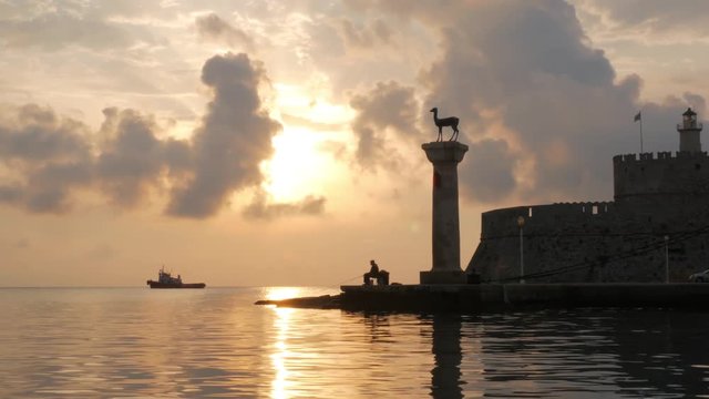 fisherman in the port of rhodes on sunrise