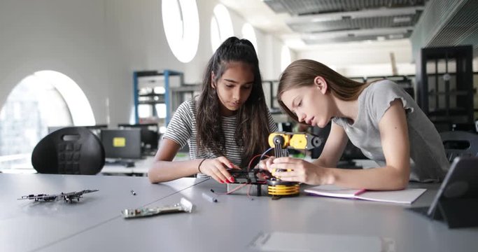 High school students working on a robotic arm in class