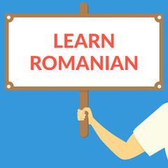 LEARN ROMANIAN. Hand holding wooden sign