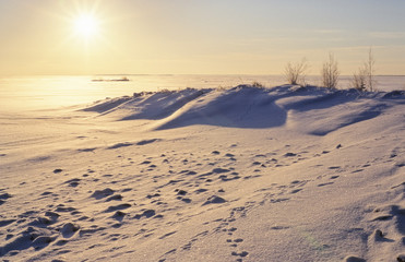 Sunshine over frozen lake on a cold winter day in Eastern Finland.