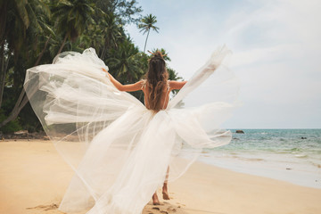 Fototapeta na wymiar Bride wearing beautiful wedding dress on the tropical beach