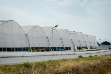 A row of plastic covered bow house tents for raspberry production