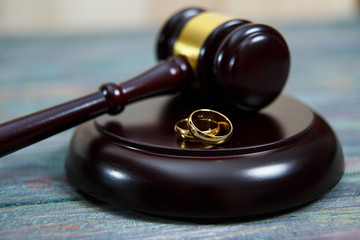 Closeup of wedding rings on wooden mallet at table