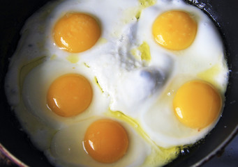 Roasted eggs on the black pan and dill over