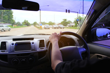 Man driver hands holding the car steering panel