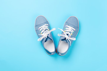 A pair of blue canvas sneakers on light blue background