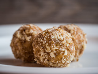 Homemade walnut balls on a white plate, traditional Christmas sweets close up